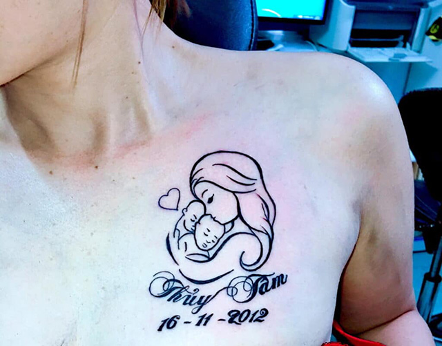 Tattoo mẹ bồng con kết hợp với chữ và ngày sinh trước ngực